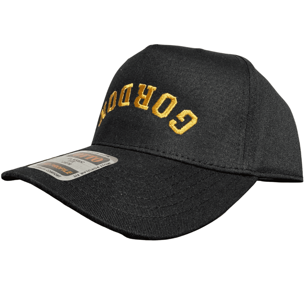 Side view of OTTO black hat with upside-down gold “Gordon” embroidery