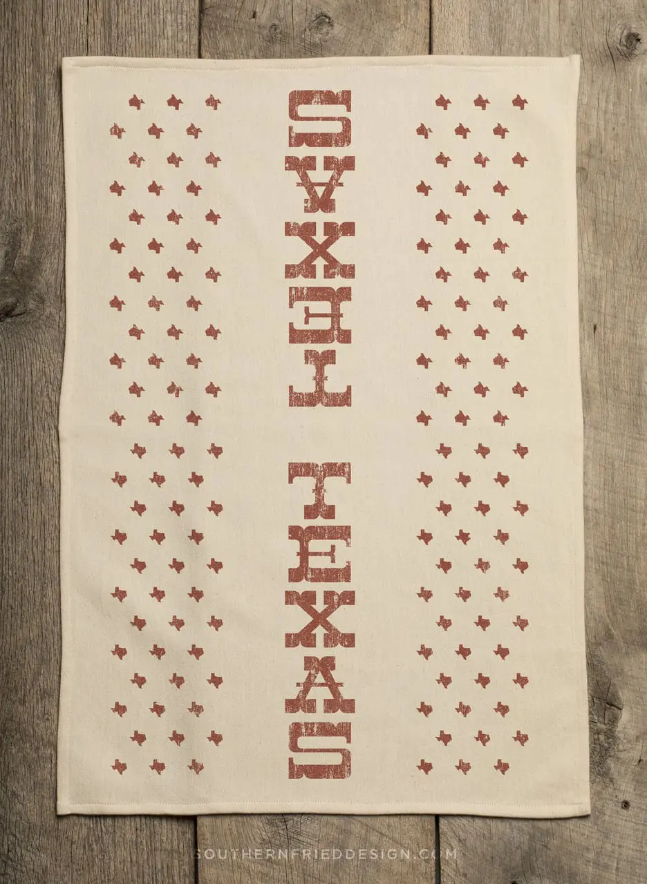 Full view of Texas kitchen towel with vertical TEXAS print and Texas-shaped stars