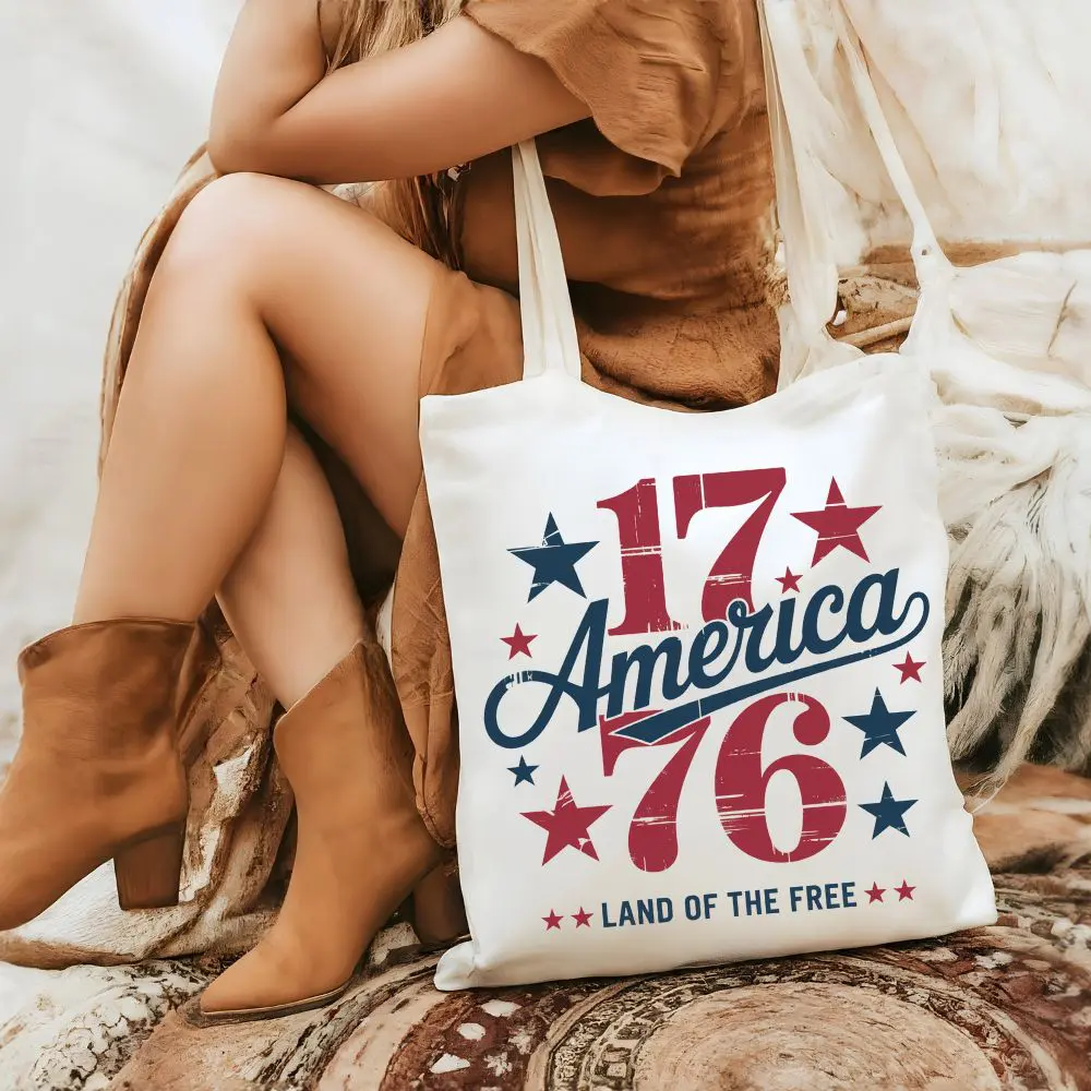 Woman holding 1776 America Land of the Free patriotic tote bag
