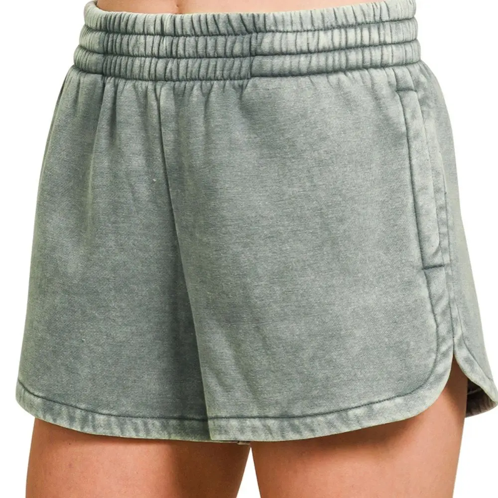 Model wearing jade acid washed elastic waistband shorts with a relaxed fit