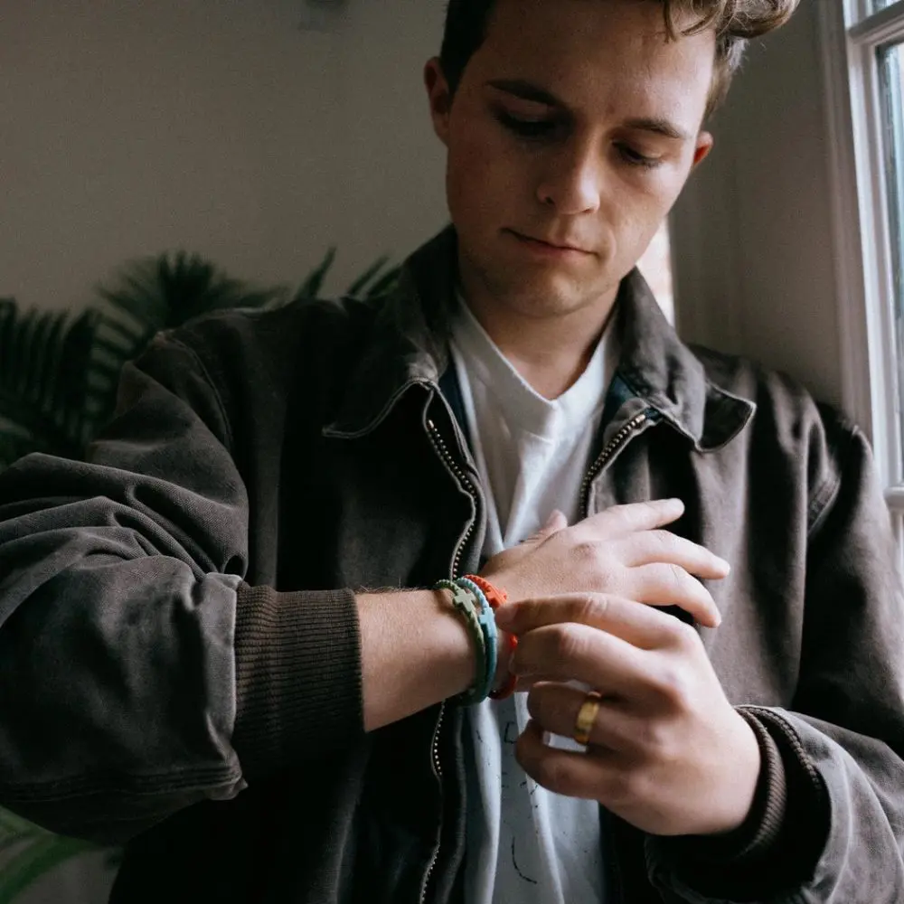 Man wearing Josiah Queen silicone bracelet stack by In God We Must