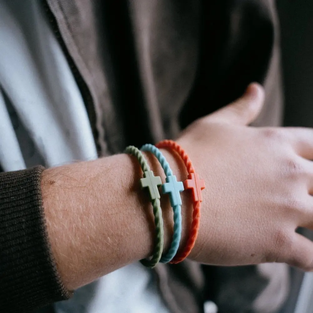Close up of Josiah Queen silicone cross bracelets by In God We Must