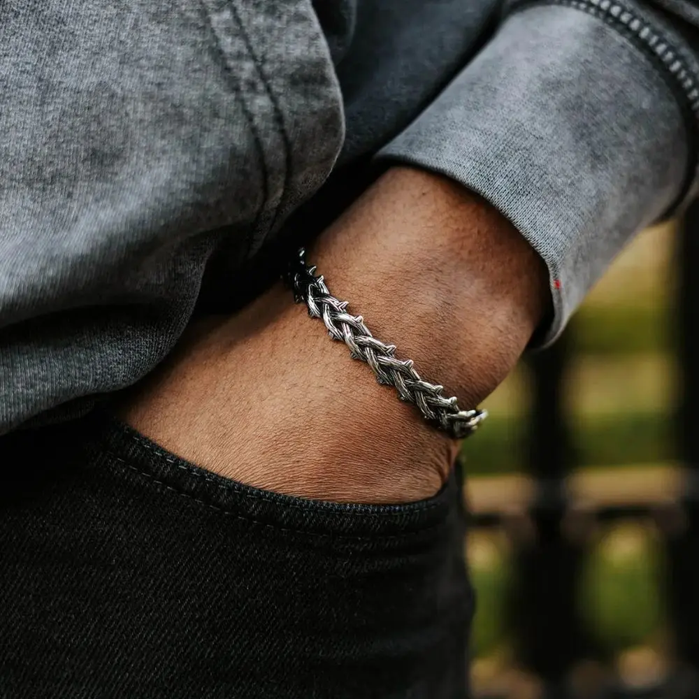 Person wearing stainless steel thorn bracelet outdoors