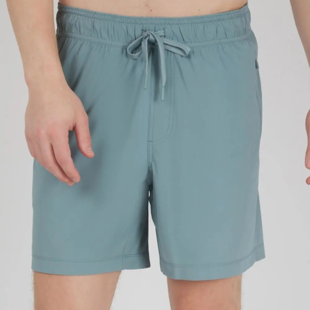 Man wearing Tornado blue stretch tech shorts with elastic waistband and drawstring closure.