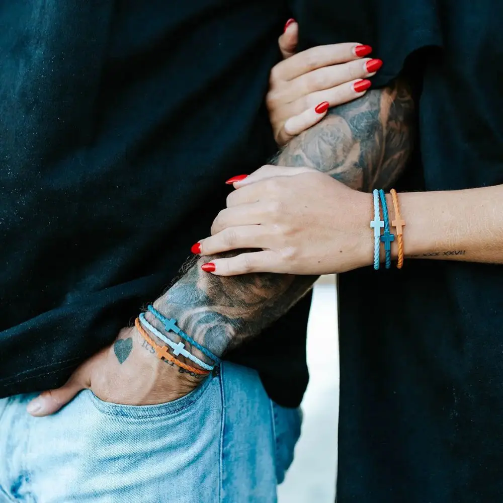Matching Daybreak Cross Bracelet Sets worn by a couple
