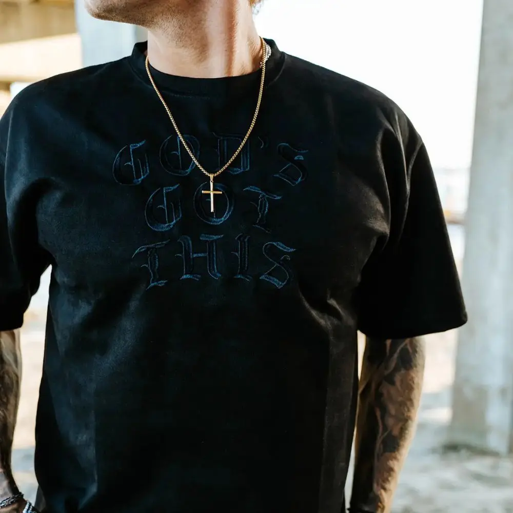 Gold stainless steel cross necklace worn casually by In God We Must model
