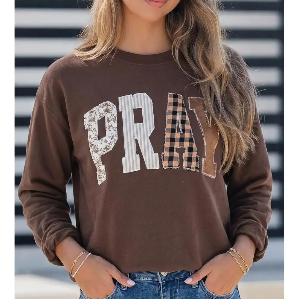 Woman wearing brown PRAY patchwork crewneck sweatshirt