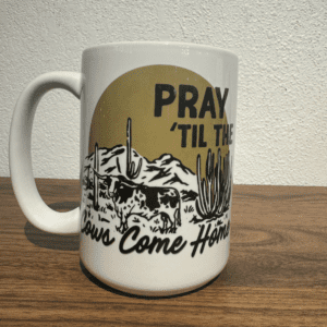 White ceramic mug with western landscape and "Pray 'Til The Cows Come Home" text