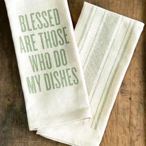 Cotton kitchen towel with green text that says “Blessed Are Those Who Do My Dishes” next to striped accent towel
