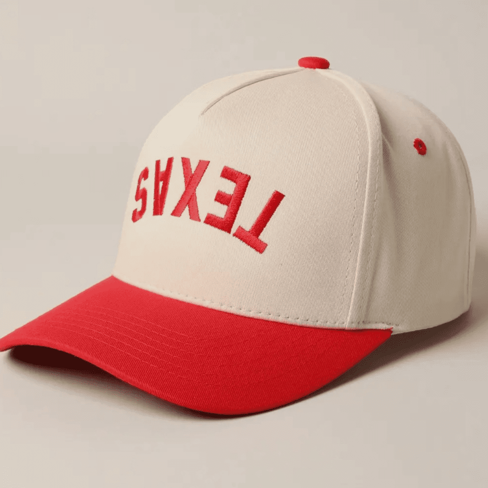 Side view of red “TEXAS” embroidered upside down on ivory fabric