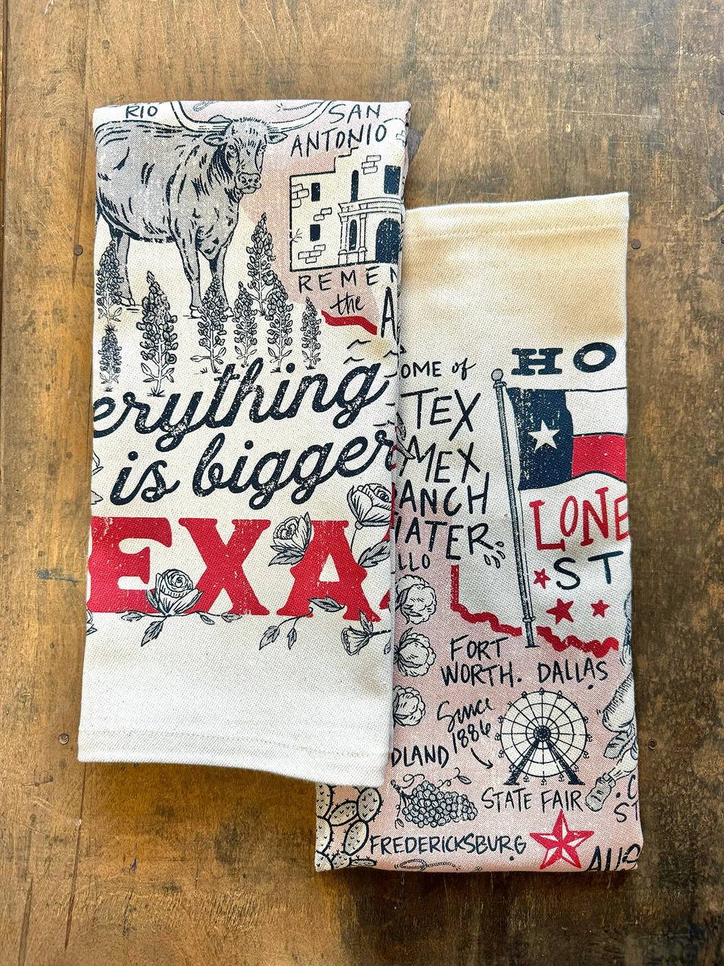 Folded kitchen towel with Texas-themed illustrations and “Everything is Bigger in Texas” text